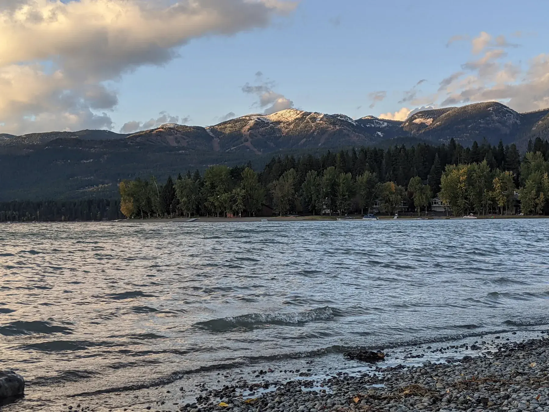 Lake, forest, and snow-covered mountains