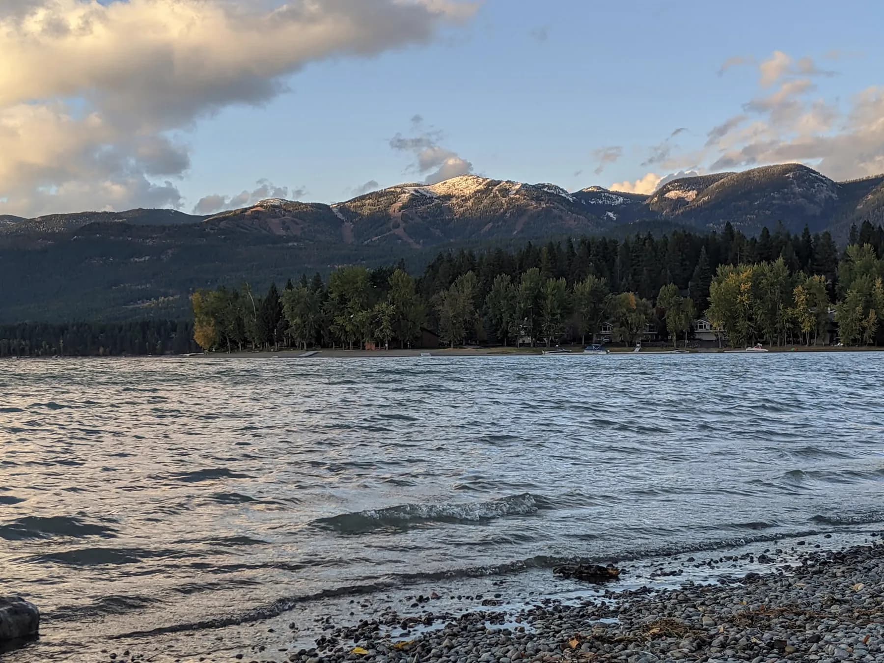 Lake, forest, and snow-covered mountains